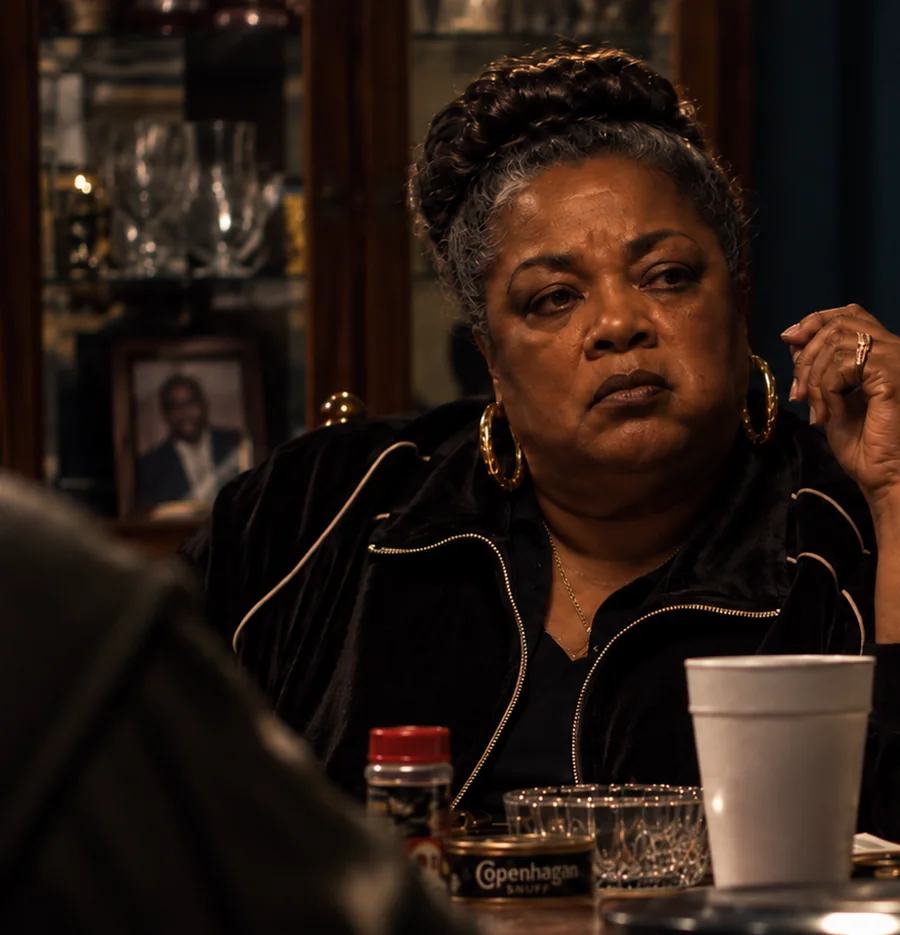 Portrait artwork of Big Mama, the family matriarch, seated at a table